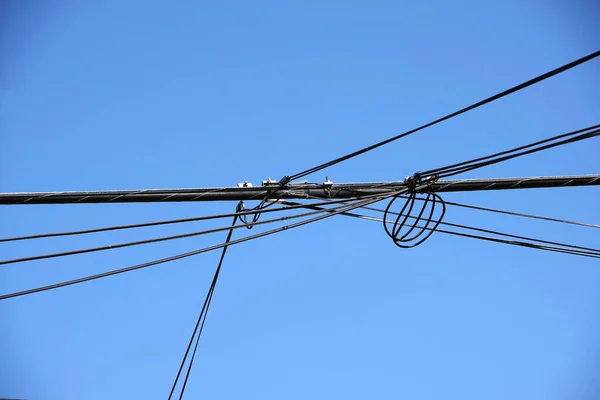 接続された電源ケーブルの上方の低角度ビュー上の明るい青空と高い — ストック写真