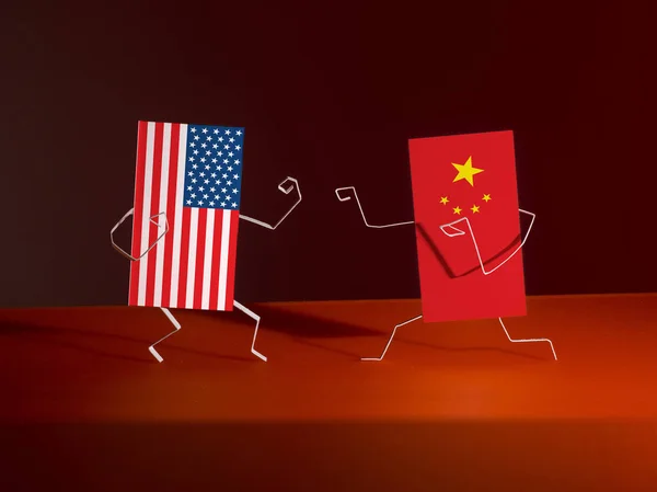 Boxing between paper flags of USA and China. Figures cut out of paper. Allegory of Economic War
