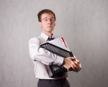 Elinde birçok muhasebe belgesi olan bir ofis çalışanı endişeli. Beyaz genç adam