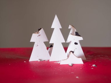 Güçlü bir yangından sonra stüdyoda Kağıt Noel ağaçları. Orman yandı. Sembol, Dünya gezegenindeki orman yangınlarının yorumu. Çevresel tehdit