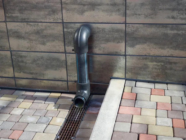 New drain pipe sticks out of the wall. Theme of urban comfortable environment and infrastructure