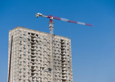 Yüksek katlı bir konut inşa ediliyor. Yüksek kule vinci çalışıyor.