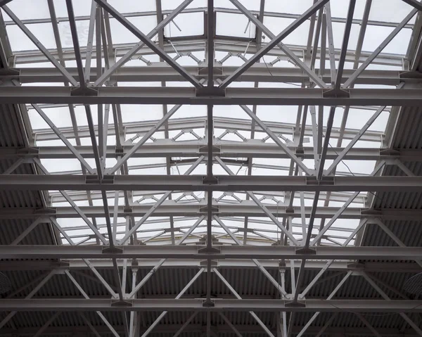 Openwork metal trusses of a huge roof in a hypermarket. Theme of modern opportunities for the construction of public facilities