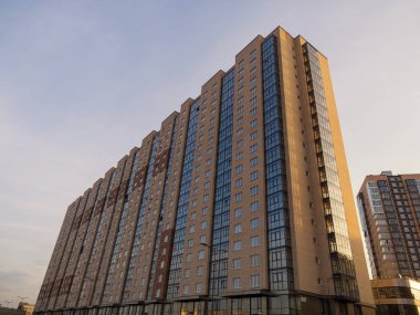 Büyük, modern tuğlalar ve camdan apartmanlar. İnşaat halindeki gelişmekte olan bir konut piyasasının teması