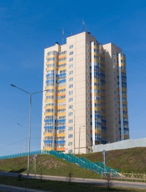 Yeni bir bölgede, mavi gökyüzünde çok katlı yeni bir ev. İnşaat halindeki gelişmekte olan bir konut piyasasının teması