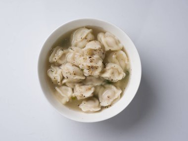 Çorbada Rus böreği. Beyaz arka planda beyaz yuvarlak kase