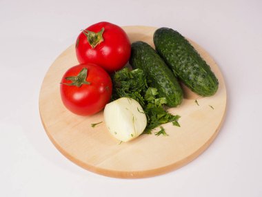 Tahtada domates, salatalık, soğan ve otlar var. Salata pişiriyorum. Sebze malzemeleri.