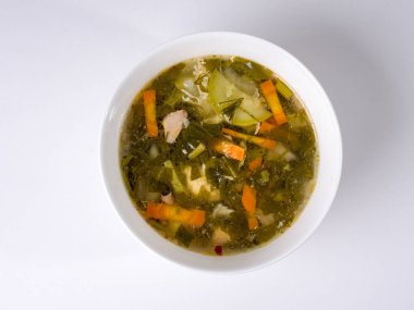 Ev yapımı sebze çorbası. Beyaz arka planda yuvarlak beyaz kase