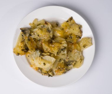 Ev yapımı patates, otlu ve ekşi kremalı. Beyaz arkaplanda beyaz bir plaka