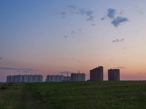 Huge beautiful sunset sky over new houses in the steppe. Development of modern cities