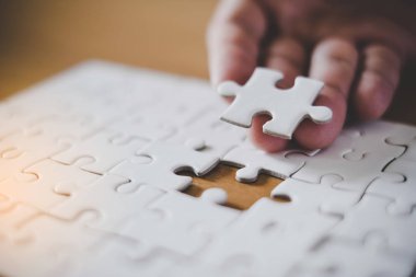 Kağıt çerçeve backg ile boş jigsaw puzzle parçası tutan el