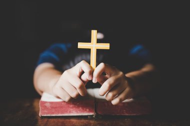 Kutsal İncil'in üzerine sabah dua kadın. Genç kadın el ile çapraz ve dua, elleri katlanmış dua Kutsal İncil'de inanç, maneviyat ve din için kilise kavramı üzerinde İncil.