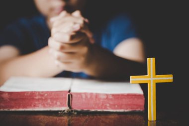 Kutsal İncil'in üzerine sabah dua kadın. Genç kadın el ile çapraz ve dua, elleri katlanmış dua Kutsal İncil'de inanç, maneviyat ve din için kilise kavramı üzerinde İncil.