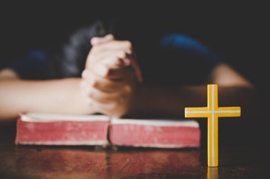 Kutsal İncil'in üzerine sabah dua kadın. Genç kadın el ile çapraz ve dua, elleri katlanmış dua Kutsal İncil'de inanç, maneviyat ve din için kilise kavramı üzerinde İncil.