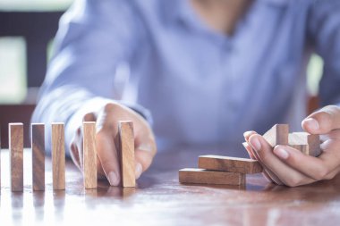 Ahşap bir masaya Domino oynuyor. Elini Domino ile.