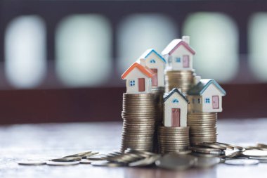 Ev modeli üzerinde sikke yığını. Konsept Emlak merdiven, ipotek ve gayrimenkul yatırım için.