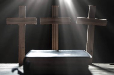 Üç haç ve Kutsal İncil'in sabah ahşap masa üzerine. Hıristiyan kavramı.