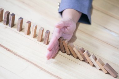 Domino etkisi parmağıyla durdurma el görüntüler. İş kriz kavramı.
