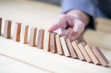 Domino etkisi parmağıyla durdurma el görüntüler. İş kriz kavramı.