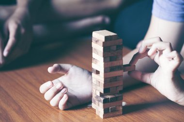Asya teen blokları kule ahşap blok ahşap masa arka plan üzerinde kelime risk ile ahşap oyun oynamak için mutlu. Kopya alanı ile metin için.