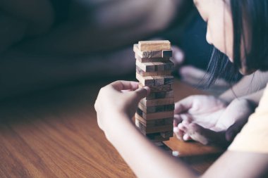 Asya teen blokları kule ahşap blok ahşap masa arka plan üzerinde kelime risk ile ahşap oyun oynamak için mutlu. Kopya alanı ile metin için.
