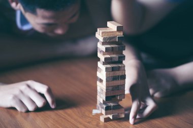 Asya teen blokları kule ahşap blok ahşap masa arka plan üzerinde kelime risk ile ahşap oyun oynamak için mutlu. Kopya alanı ile metin için.