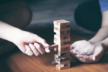 Asya teen blokları kule ahşap blok ahşap masa arka plan üzerinde kelime risk ile ahşap oyun oynamak için mutlu. Kopya alanı ile metin için.