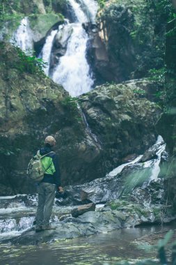 Şelale güzel yaz doğa manzara bakarak backpacker. Erkek yetişkin geri açık duran portresi.