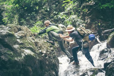 Dağ dere şelale ile yürüme yardım iki yürüyüşçü genç adam tutuşup