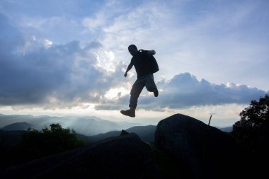 Adam uçurumun mavi gökyüzü atlama