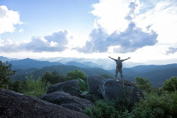 Dağ aralıkları bir vista üzerinde seyir kaldırdı kollarını ile yüksek kayalık tepe ayakta zirvesine ulaşan kutluyor dağcı