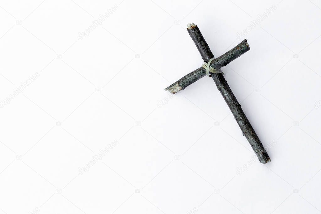 Cross made from tree branch isolated on white background