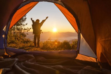 Uzun yürüyüşe çıkan kimse standında kamp açık turuncu çadır ve dağlarda sırt çantası. Mesafe içine arayan backpacker