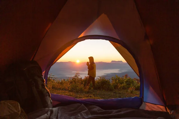 キャンプの正面のオレンジ色のテントと山中のバックパックにハイカーの立っています 遠くを見ているバックパッカー — ストック写真