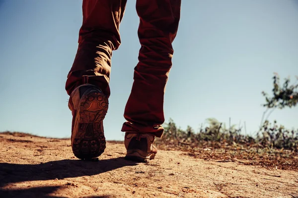 hiking shoes in action on a mountain desert trail path. Close-up of male hikers shoes