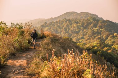 En yüksek dağında gün batımı zevk sırt çantası ile yenilikçi genç adam