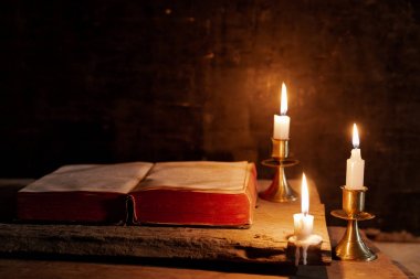 İncil bir mum yanındaki bir masada açık. 