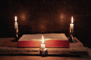 İncil bir mum yanındaki bir masada açık. 
