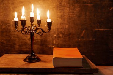 Kutsal Kitap ve mum eski bir meşe ahşap masa üzerinde. 