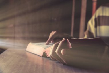 odada İncil veya kitap okurken bir adam sittding 