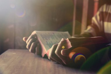 odada İncil veya kitap okurken bir adam sittding 