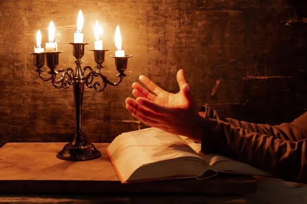 Religious female crossed hands in prayer with bible and candle, — Stock Photo, Image