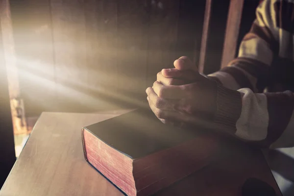 Hombre irreconocible sosteniendo una Biblia en sus manos y rezando —  Fotos de Stock