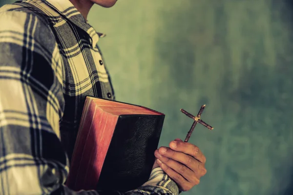 Un jeune homme tenant une bible dans ses mains — Photo