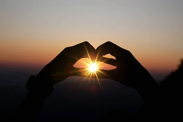 Forme de coeur de deux mains avec fond de lever de soleil . — Photo