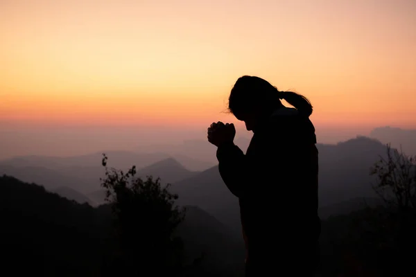 Silhueta de menina orando sobre belo fundo do céu. Cristo. — Fotografia de Stock