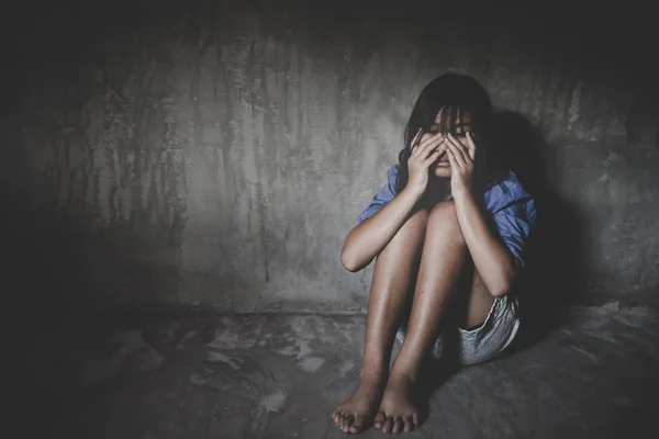 Niña triste sentada contra la pared desesperada . —  Fotos de Stock