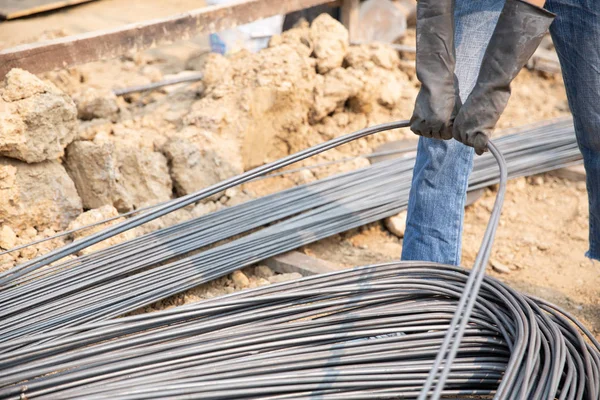 Un grupo de varilla de acero apretado por cadena y levantar en el sitio de construcción —  Fotos de Stock