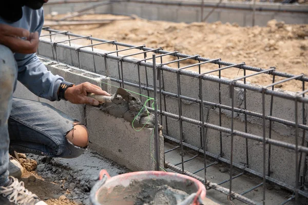 Murare arbetare installera tegel murverk på ytterväggen — Stockfoto