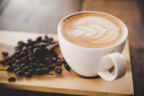 Secangkir kopi latte di meja kayu di kafe kedai kopi — Stok Foto